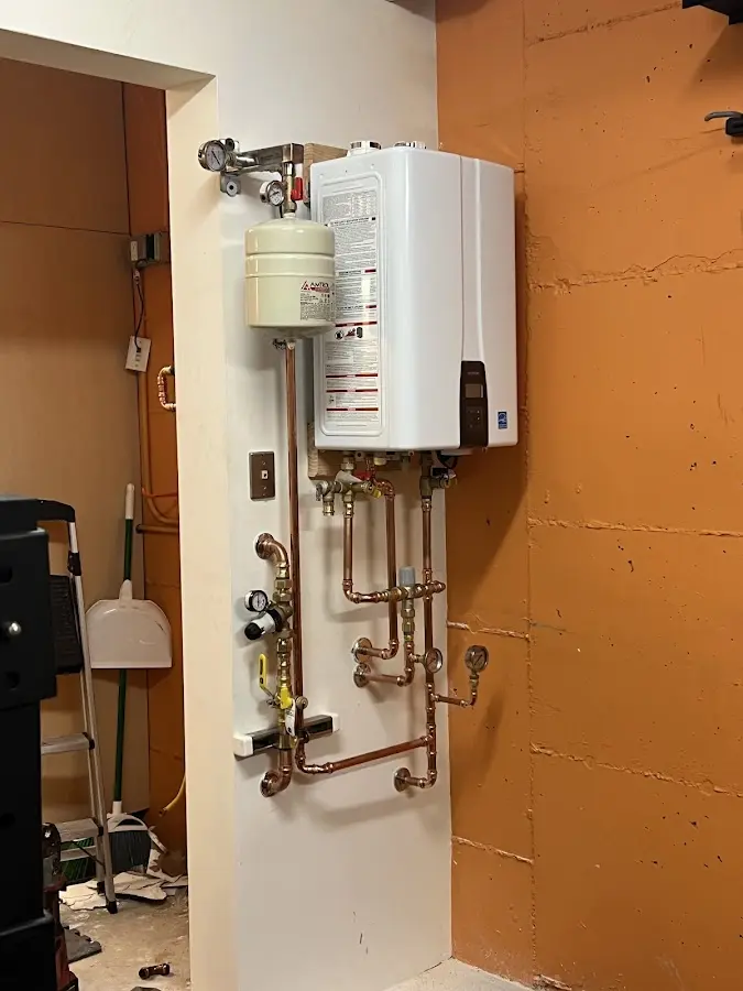 Plumbing technician inspecting water heater connections in Nokomis